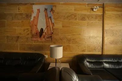 a living room with two leather chairs and a table with a lamp at Petra Aretas Hotel in Wadi Musa