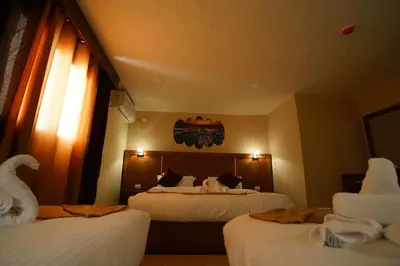 a hotel room with two beds and a swan on the wall at Petra Aretas Hotel in Wadi Musa