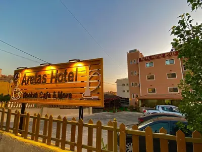 a sign in a parking lot next to a building at Petra Aretas Hotel in Wadi Musa