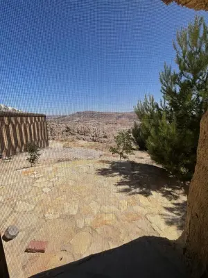 a view of a desert with trees and a blue sky at Al-Nawatef ECO camp- Dana Nature Reserve in Dana