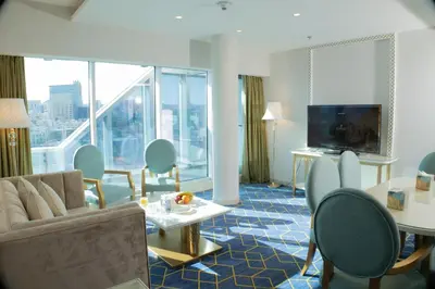a living room with a couch and chairs and a television at Coral Tower Hotel by Hansa in Amman