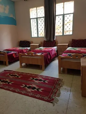 a room with three beds and a rug at Dana moon Hotel in Dana