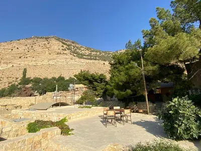 a table and chairs in front of a mountain at Dana moon Hotel in Dana