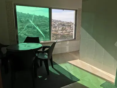 a dining room with a table and chairs and a large window at Euphoria guest house in Wadi Musa