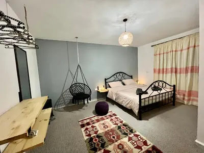 a bedroom with a bed and a chair and a table at Euphoria guest house in Wadi Musa