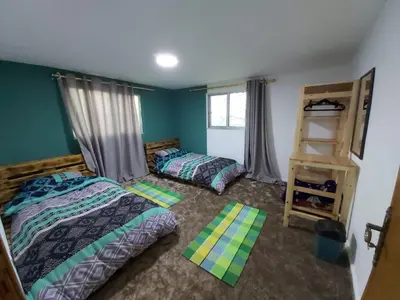 a bedroom with two beds and a book shelf at Euphoria guest house in Wadi Musa