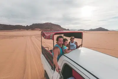 two men in the back of a truck in the desert at Wadi Rum Nova camp in Wadi Rum