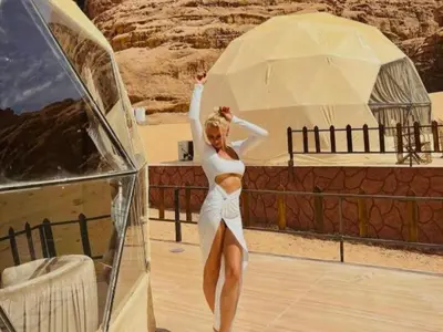 a woman in a white dress standing under an umbrella at Wadi Rum Nova camp in Wadi Rum