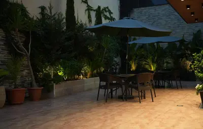 a table and chairs with an umbrella in a courtyard at Abu Alsoud Hotel in Amman