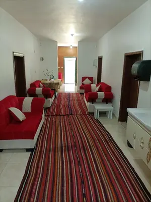 a living room with red couches and a large rug at Happy Night Hostel in Wadi Musa