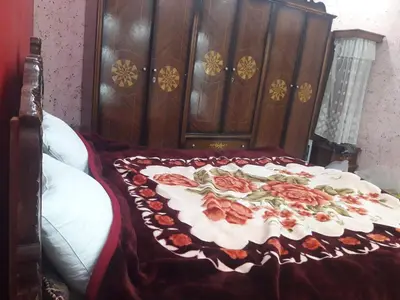 a bed with a red and white blanket on it at WadiRum Village Lodge in Wadi Rum