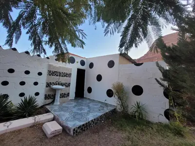 a house with a bench in front of a wall at WadiRum Village Lodge in Wadi Rum