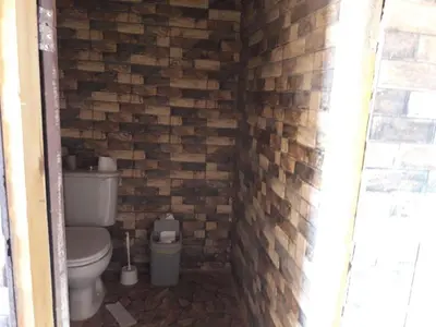 a bathroom with a toilet and a brick wall at WadiRum Mobile Camp in Wadi Rum