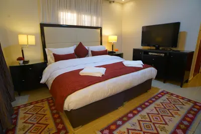 a bedroom with a large bed and a flat screen tv at Over Mountains Hotel in Wadi Musa