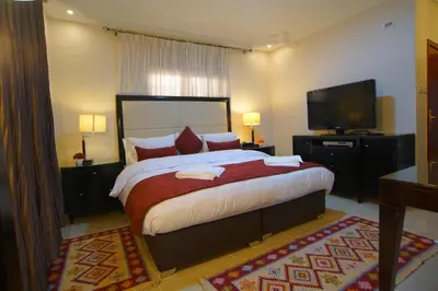 a bedroom with a large bed and a flat screen tv at Over Mountains Hotel in Wadi Musa