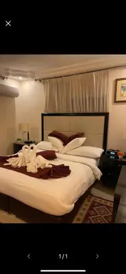 a bedroom with a large bed with white sheets at Over Mountains Hotel in Wadi Musa