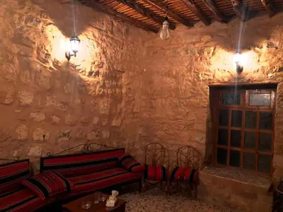 a room with two red benches in a stone wall at The Orient Home in Wadi Musa