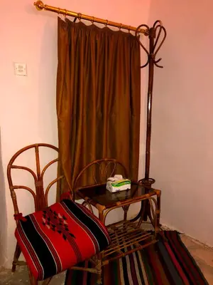 a room with a chair and a table and a curtain at The Orient Home in Wadi Musa
