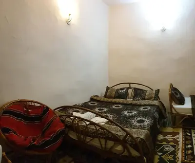 a bedroom with two beds and a chair at The Orient Home in Wadi Musa