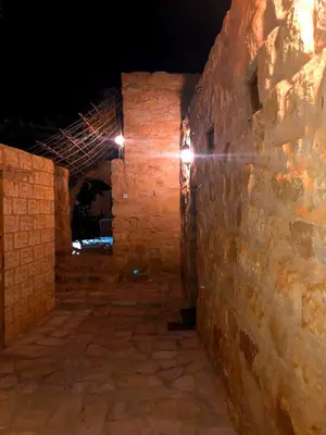 an alley in an old stone building at night at The Orient Home in Wadi Musa