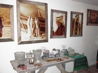 a table with artifacts on a wall with pictures at Ammarin Bedouin Camp in Wadi Musa