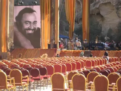 an auditorium with chairs and a large picture of a man at Ammarin Bedouin Camp in Wadi Musa