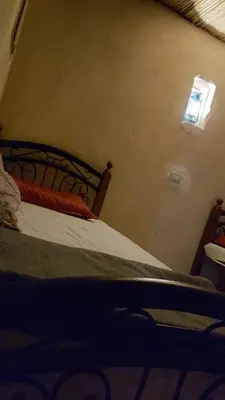 a bedroom with a bed with a light on the wall at Wadi Ghwere Camp مخيم وادي الغوير in Al Khuraybah