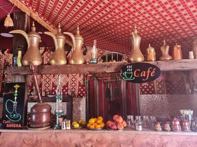 a shelf filled with lots of copper vases and other items at Wadi Rum Caravan Camp in Wadi Rum