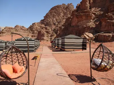 a view of a desert with tents and rocks at Wadi Rum Caravan Camp in Wadi Rum