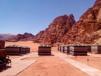 a view of the desert with mountains in the background at Wadi Rum Caravan Camp in Wadi Rum