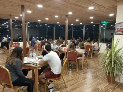 a group of people sitting at tables in a restaurant at Petra Cabin Hostel in Wadi Musa
