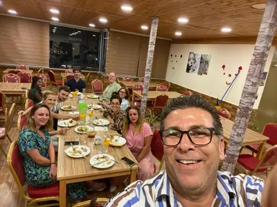 a man sitting at a table with a group of people at Petra Cabin Hostel in Wadi Musa