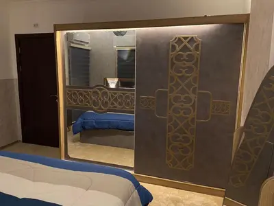 a bedroom with a mirror and a bed in a room at شركة مسايا لشقق المفروشة in Irbid