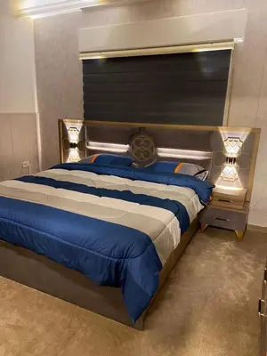 a bedroom with a large bed with blue sheets at شركة مسايا لشقق المفروشة in Irbid