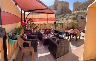 a patio with couches and tables and a castle at Bubble castle in Kerak