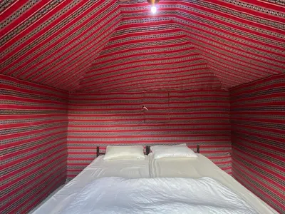 a bedroom with a red and black striped wall at Wadi Rum Quiet Sky in Wadi Rum