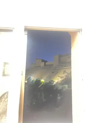 a view of a building from inside a window at the old house in Kerak