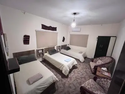 a hotel room with two beds and a chair at the old house in Kerak