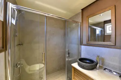a bathroom with a shower with a sink and a mirror at Palmera Camp Wadi Rum in Wadi Rum