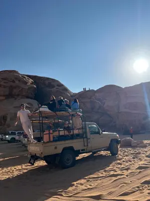 a group of people riding in the back of a truck at Wadi Rum Mars Camp in Wadi Rum
