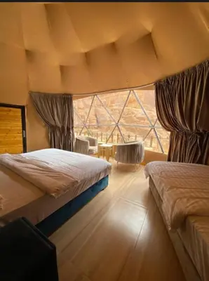 a bedroom with two beds and a large window at Wadi Rum Mars Camp in Wadi Rum
