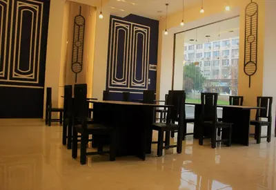 a dining room with tables and chairs and a window at New MerryLand Hotel in Amman