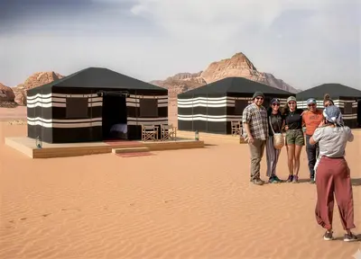 a group of people standing in the desert at One Thousand and One Nights Camp in Wadi Rum