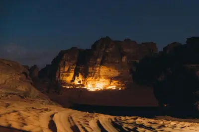 a view of a mountain in the desert at night at One Thousand and One Nights Camp in Wadi Rum