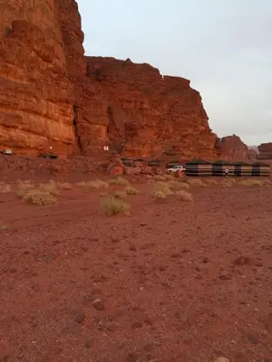 a train traveling through the desert near a rocky mountain at Wadi Rum in Wadi Rum