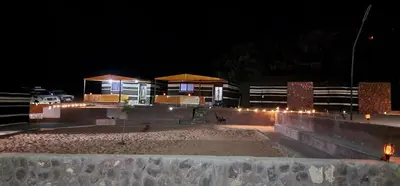 a night view of a building with lights at Real Bedouin life &tour in Wadi Rum