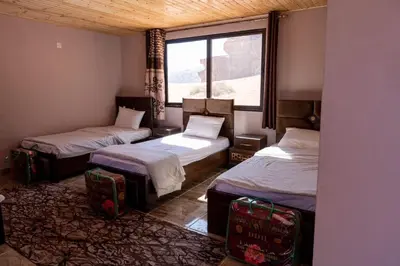 a room with two beds and a window at Real Bedouin life &tour in Wadi Rum