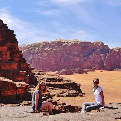 two women sitting on the rocks in the desert at WADI RUM STAR WARS CAMP in Wadi Rum
