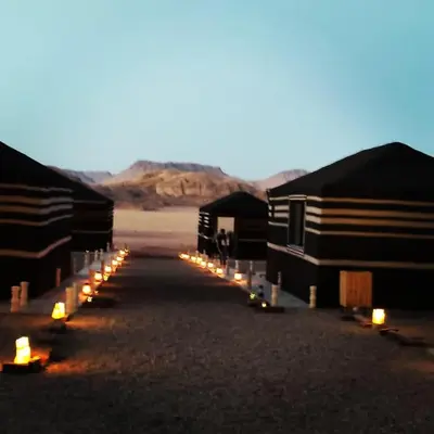 a row of huts with candles in the desert at WADI RUM STAR WARS CAMP in Wadi Rum