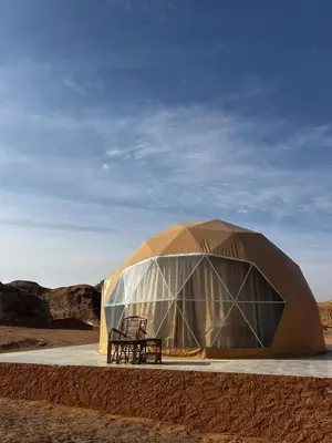 a tent with a bench in the desert at Wadi Rum Maracanã camp in Wadi Rum